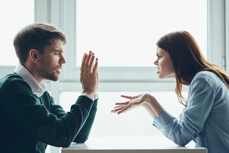 man woman sat at table arguing