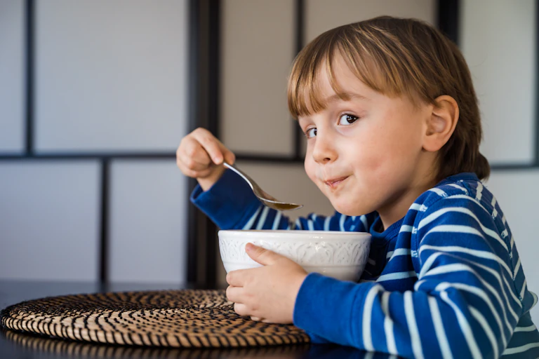 Little girl eating from bowl