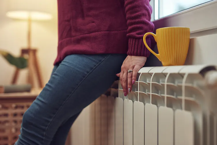 A person leaning on a radiator.