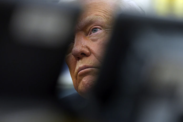 An elderly man's tanned face is partially obscured.