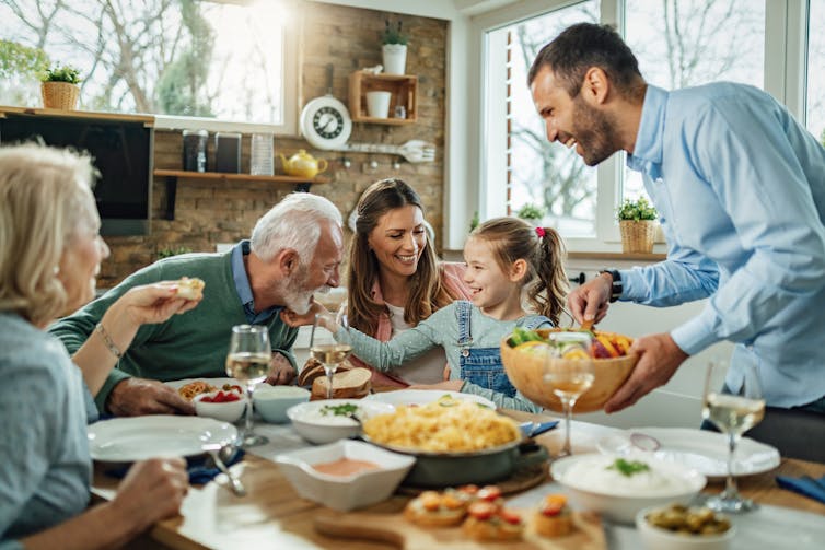 Parents, grandparents and child around dinner table