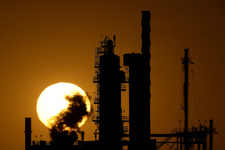Planta industrial em silhueta contra o sol