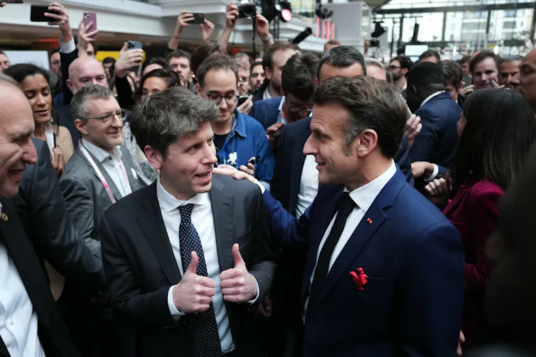 Photo of two men in business suits in a crowd of men in business suits.