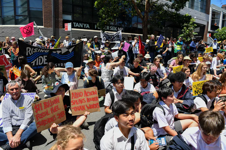 Young people in school uniforms at a school climate change protest.