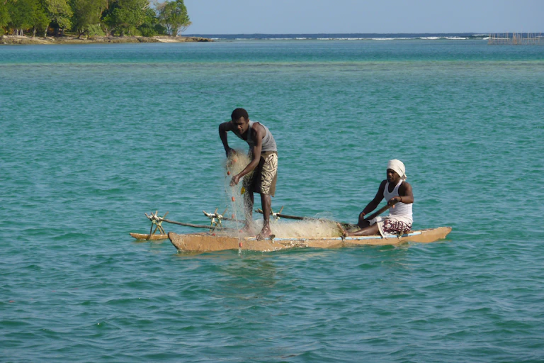Two peopel in an outrigger canoe, fishing in Port Vila lagoon