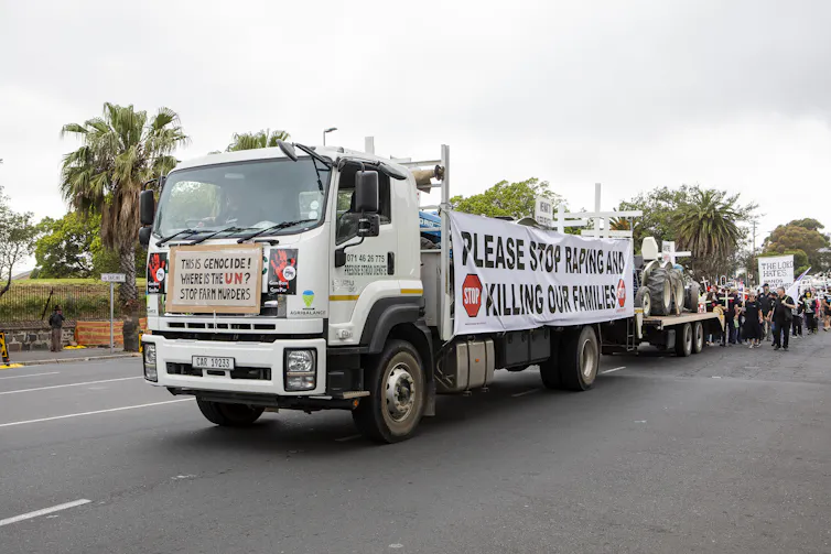 Farmers and supporters protest against farm murders outside the South African parliament in 2020. The banner on the front of the truck says the murders are genocide.