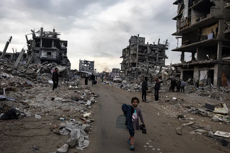 A young boy in the rubble of a Gaza street.