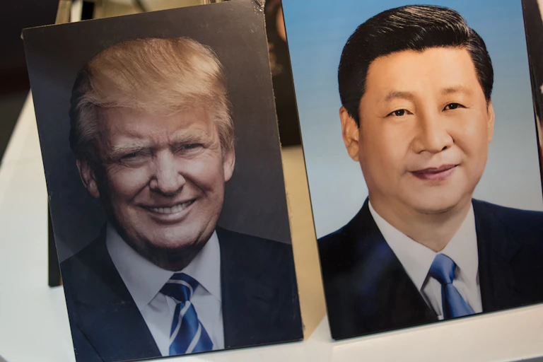 Framed photographs of Chinese President Xi Jinping (R) and US President Donald Trump.