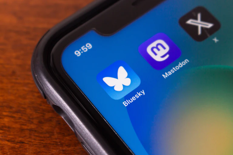 A phone with icons for Bluesky, Mastodon, X