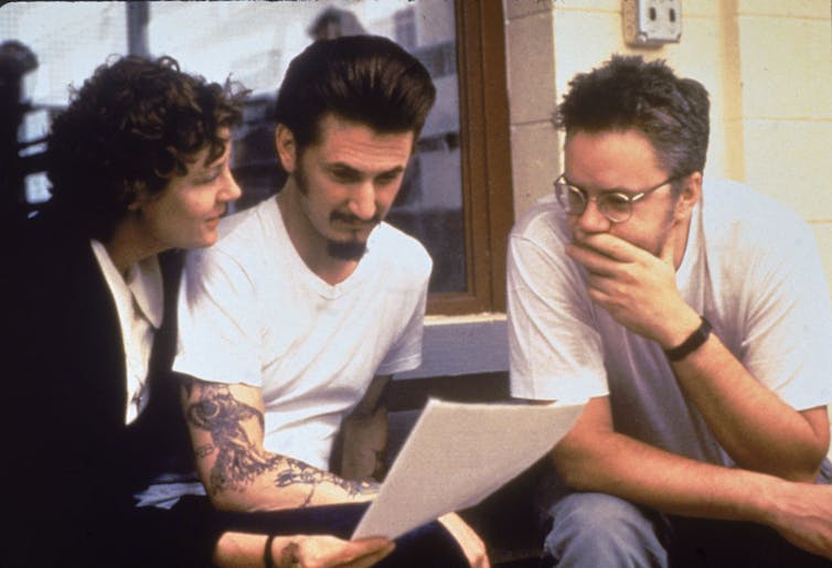 Three actors consult a script.
