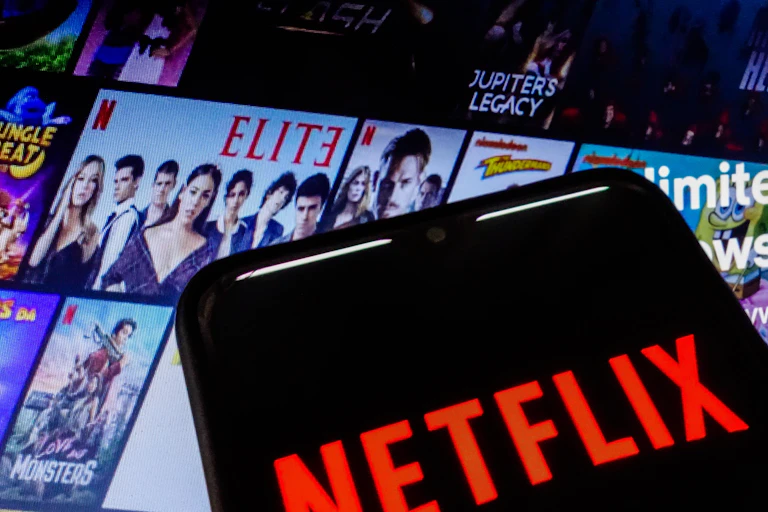 A phone showing Netflix seen against another screen showing viewing options.