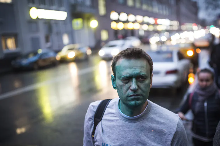 Alexei Navalny with his face covered in green dye in a Moscow street