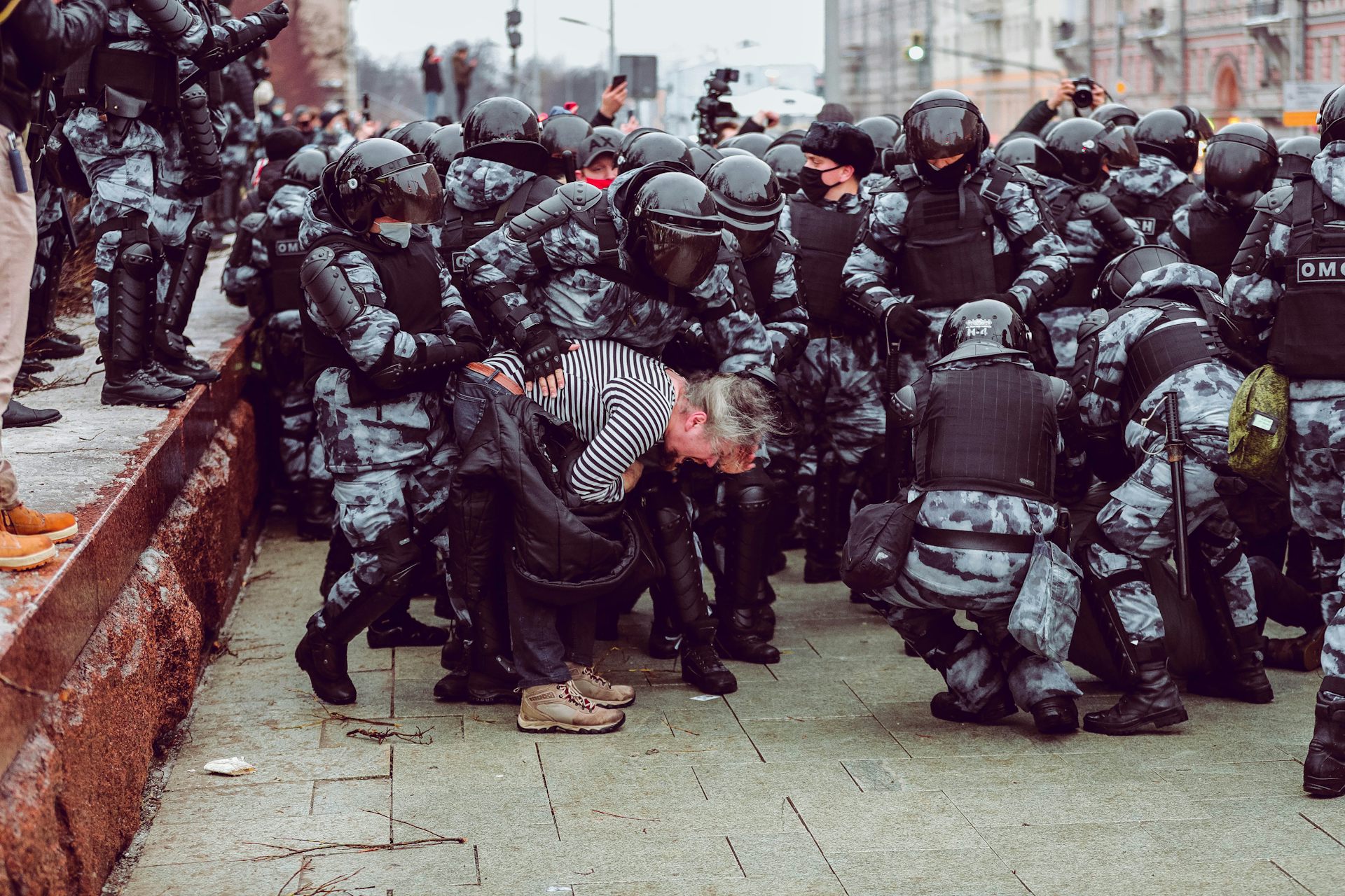A crowd of riot police surround a Russian protester