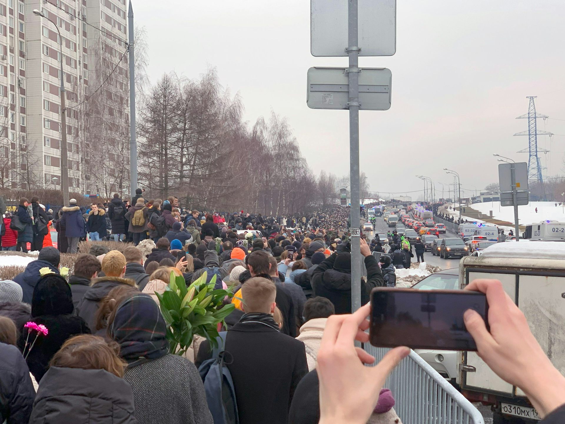 Large crowds beside a road on the day of Alexei Navalny's funeral