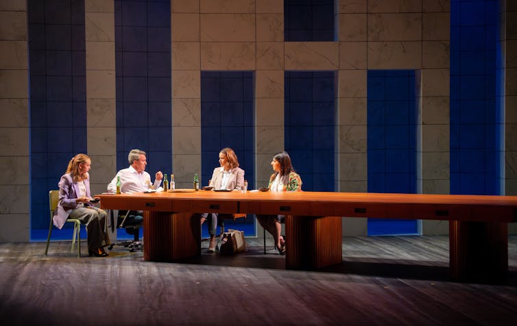 Four people eat dinner at a long table.
