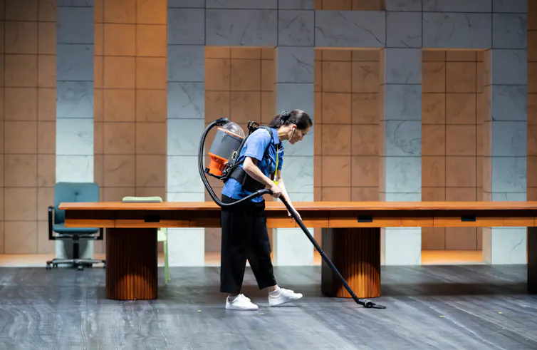 A woman vacuums.