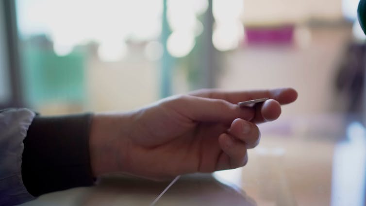 Photo of a man's hand about to flip a coin.