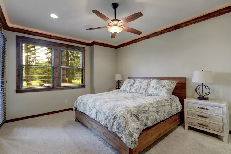 A bedroom with a ceiling fan
