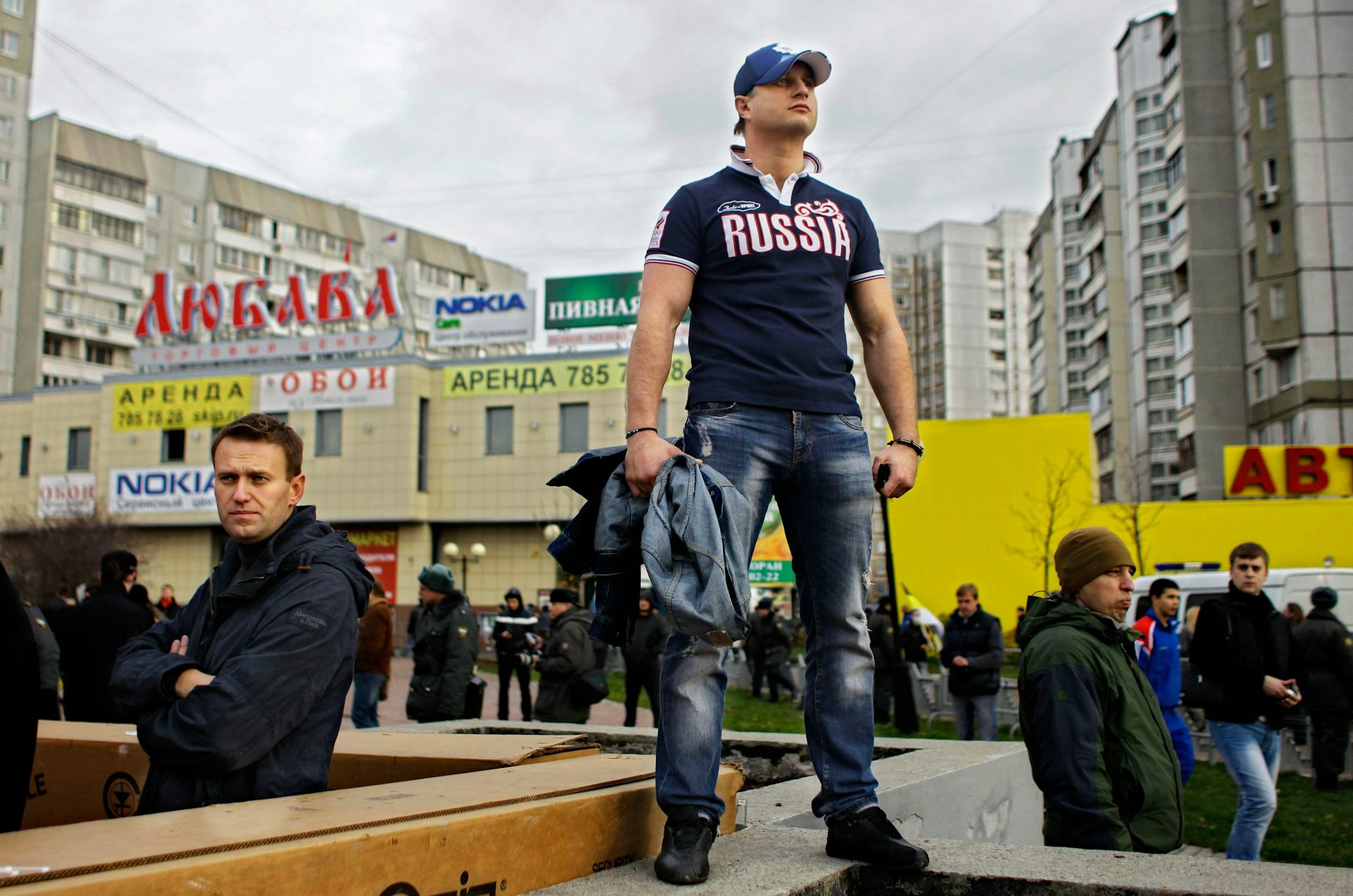 Alexei Navalny stands next to a man wearing a 'Russia' shirt at a nationalist march