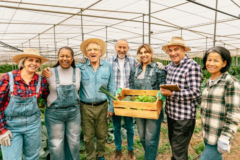 Des coopérateurs montrent leurs production sous une serre.