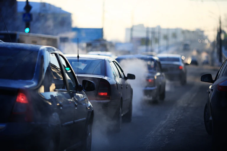 cars in traffic, fumes coming from tyres/exhaust