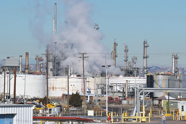 A powerplant emitting smoke on a sunny day.