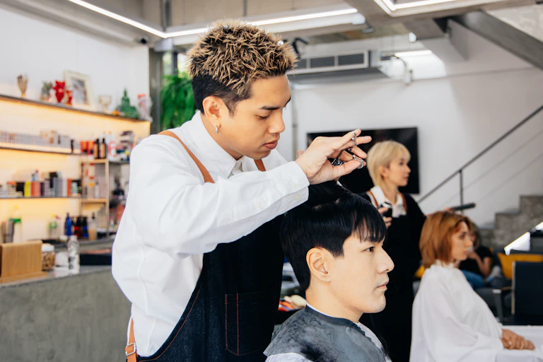 Hairdresser cuts mans hair in a salon