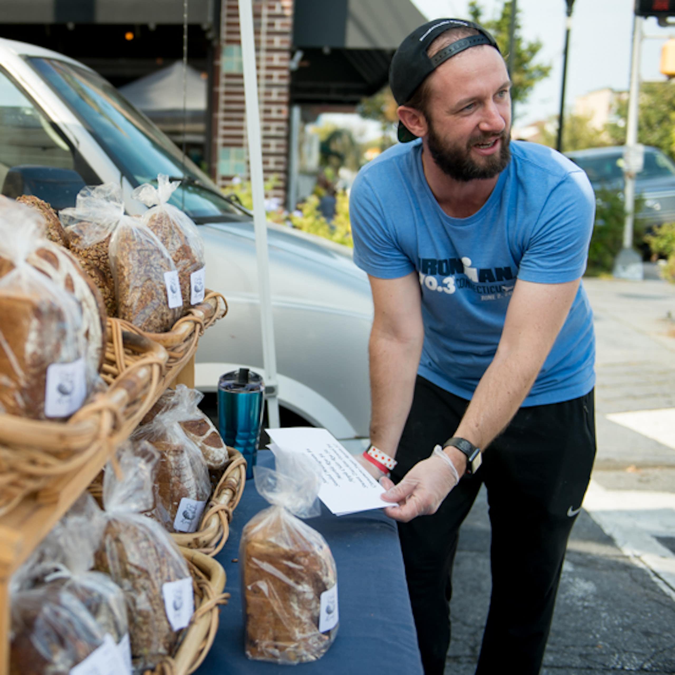 A man reaches for an order of bread for a customer.
