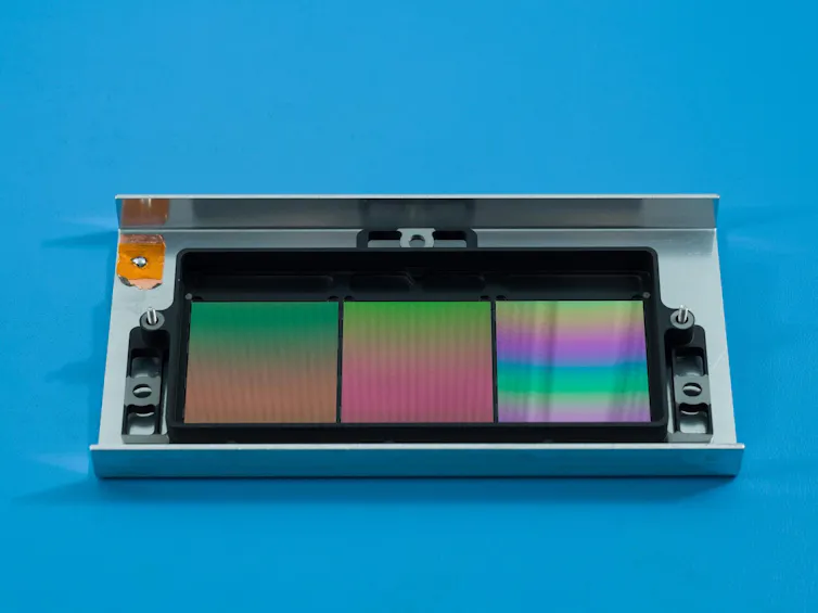 Small metal casing containing three rainbow-coloured plates.