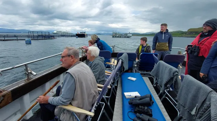 Tourists visiting a salmon farm in a loch near Oban in Scotland