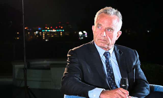 RFK Jr. on a stage in front of a mic.