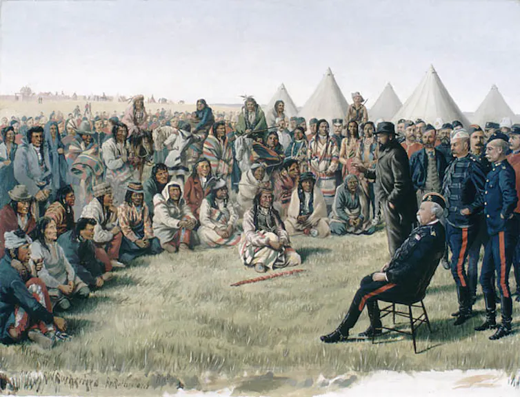 Painting of a group of people in a circle, some seated and some standing, in front of a seated soldier in uniform.