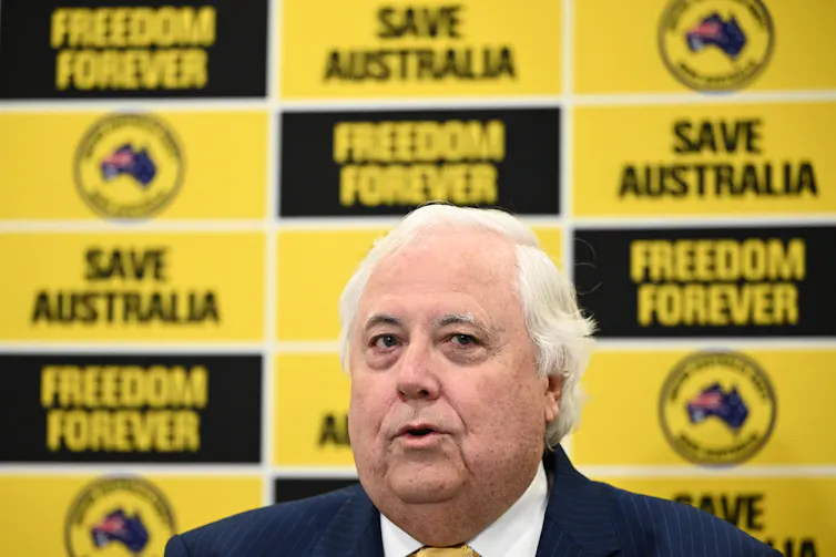 A man with white hair in front of a bright yellow and black background
