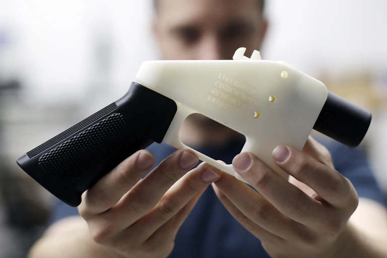 man holding a 3D-printed pistol