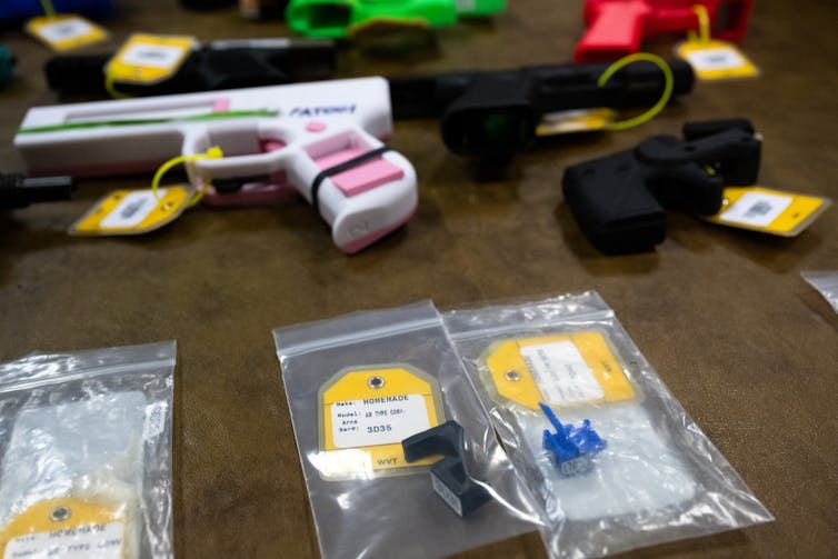 Plastic 3D-printed guns and parts on a table.