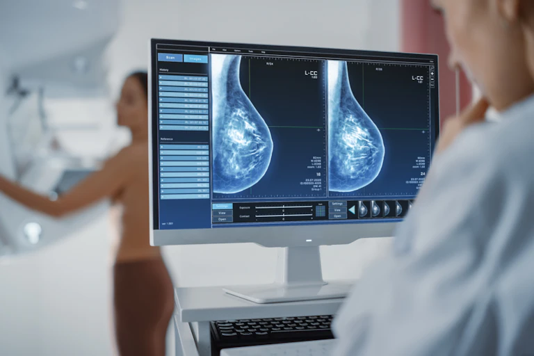 Radiologist looks at an x-ray image of a breast during a mammogram.
