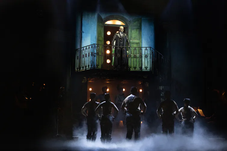Hades looks down over the ensemble.