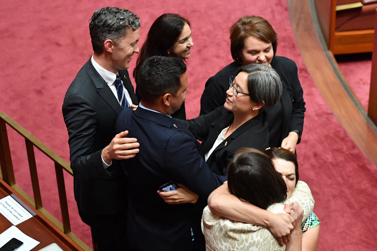 Several politicians and others hugging in parliament after the marriage equality vote.