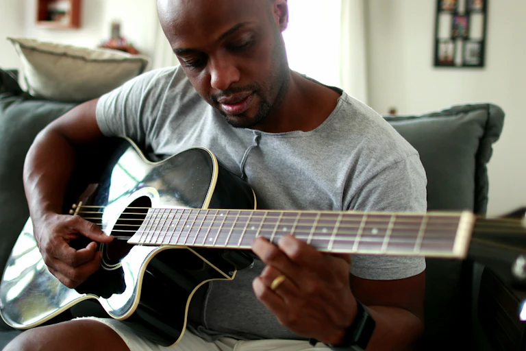 Man practicing guitar at home.