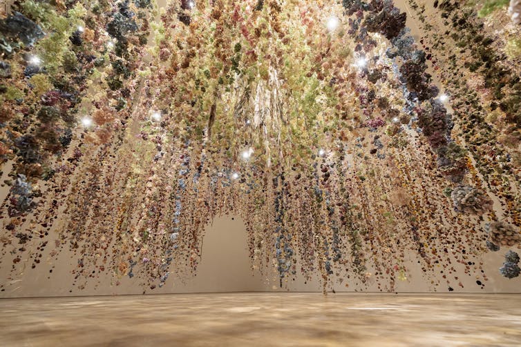 Strings of flowers hanging from a white ceiling.
