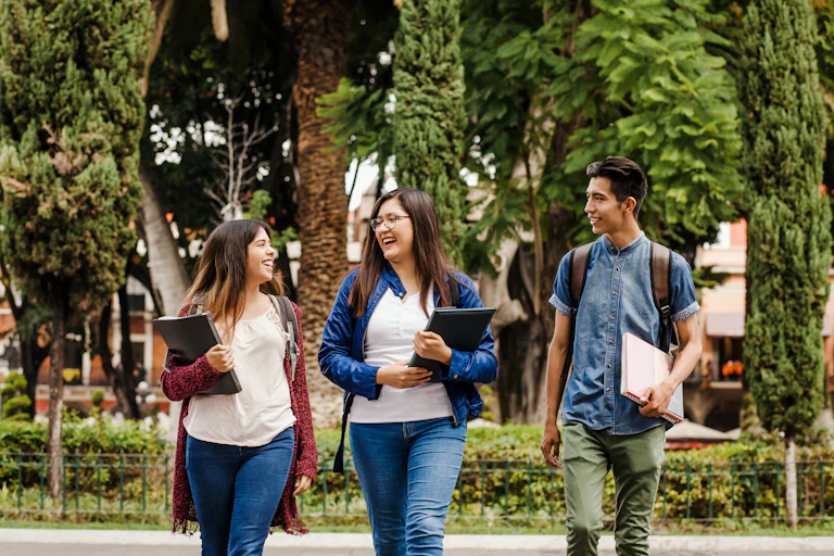 Three Latino/a students walking outside