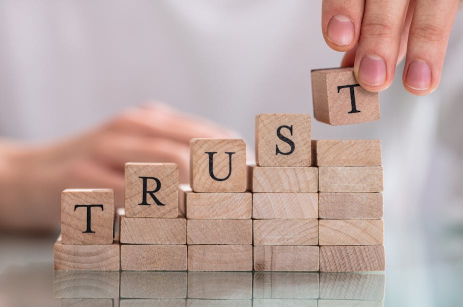 The word "Trust" is spelled out in wooden blocks.