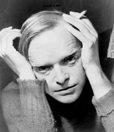Truman Capote holds his head in his hands.