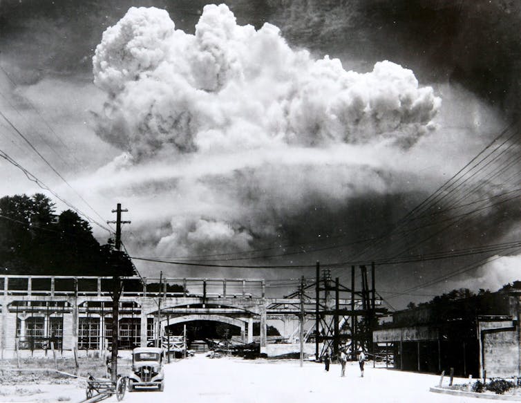 A huge mushroom cloud above a Nagasaki street.