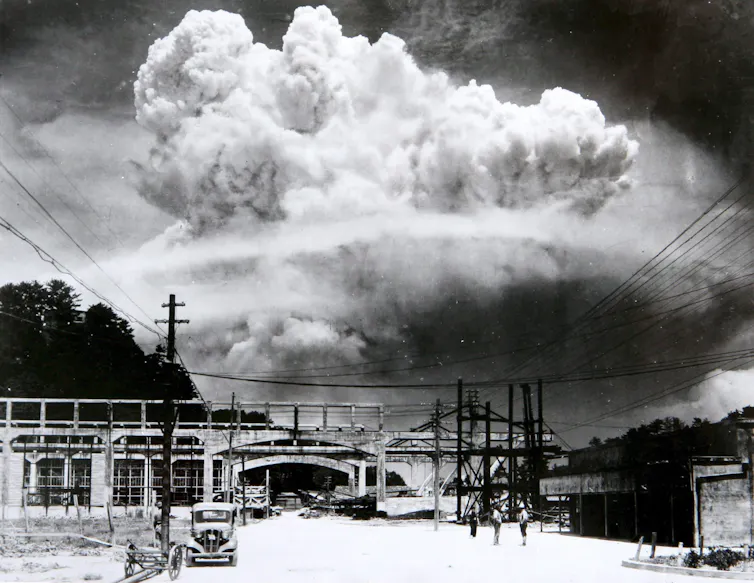A huge mushroom cloud above a Nagasaki street.