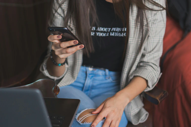 Une jeune femme regarde son téléphone.