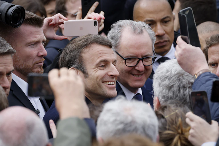 Emmanuel Macron et Richard Ferrand au milieu d'une foule lors de la campagne présidentielle de 2022.