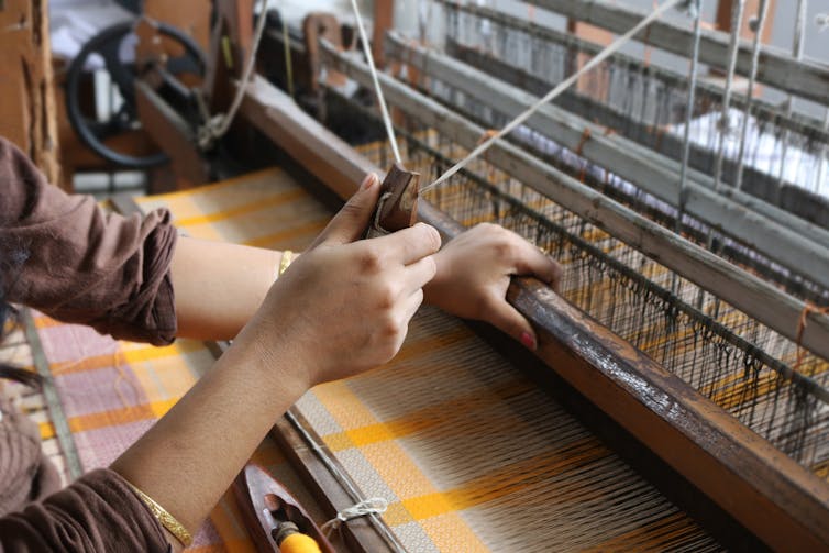 hands of a textile weaver working at her loom in India