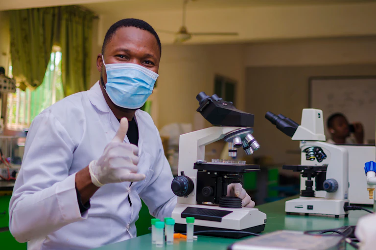 Young man in a laboratory gives a thumbs up.