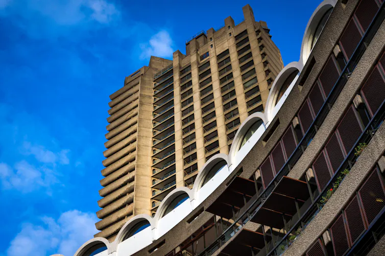 The brutalist Barbican estate in London against a bright blue sky.